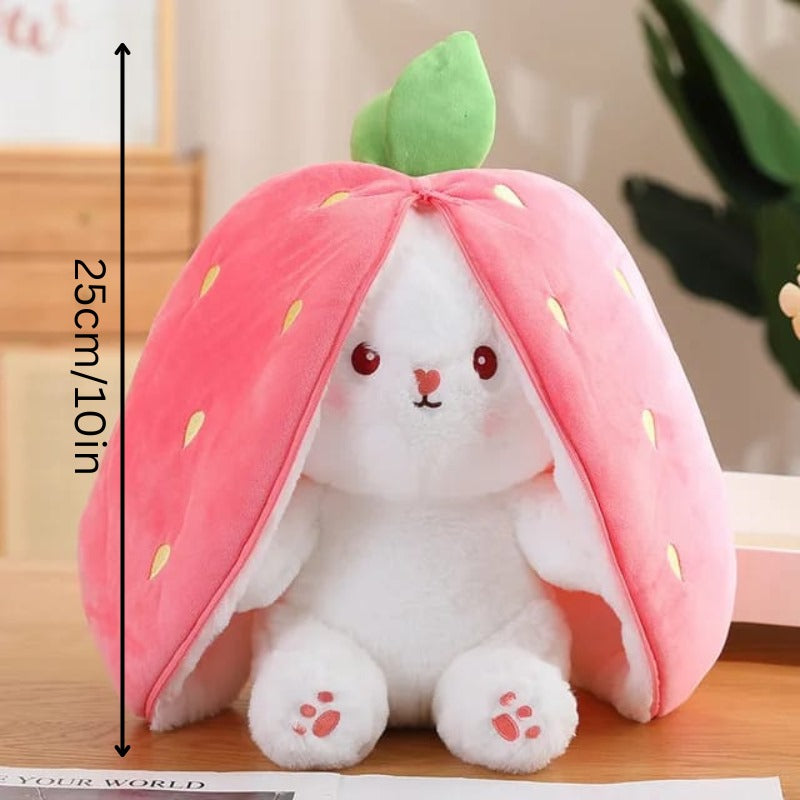 Plush toy shaped like a strawberry with a white rabbit inside on a wooden surface.
